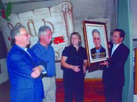 Os presidentes da Junta e da ACDUC e um membro da Comissão Fabriqueira oferecendo o retrato ao homenageado