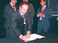 Paulo Campos rubricando o contrato